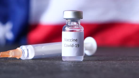 Close Up of Coronavirus Vaccine and Syringe o American American Flag 