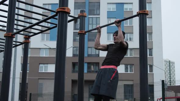 Muscular man training outdoors on sports field