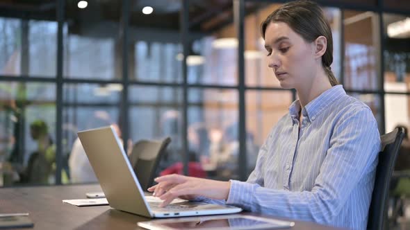 Busy Young Woman Working on Laptop