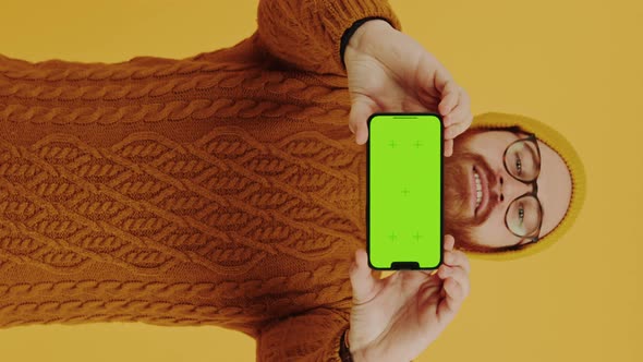 Look at the Phone Young Man Showing Mobile Phone Blank Screen Orange Background Studio Shot Medium