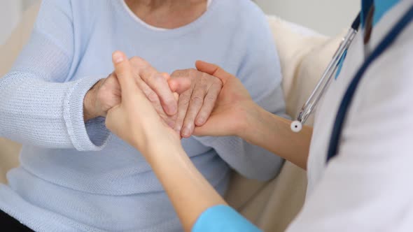 Hand Of Doctor Reassuring Her Senior Female Patient