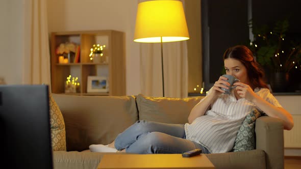 Pregnant Woman Watching Tv and Drinking Tea