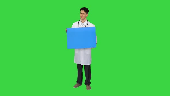 Smiling Male Doctor Wearing a Stethoscope Holding Blank Poster on a Green Screen, Chroma Key.