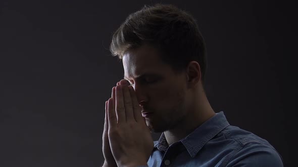 Young Man Praying Faithfully, Looking for Solution to Difficult Life Problem