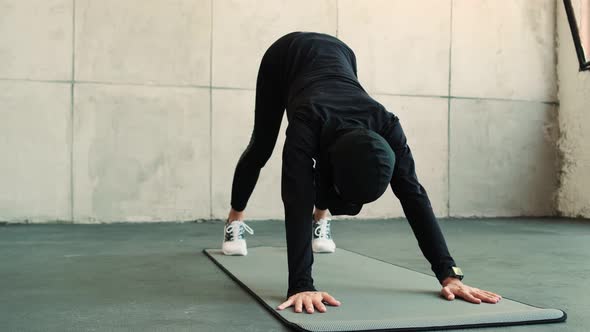 A beautiful arabian sports woman wearing a national hijab do exercises