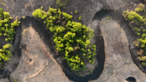 Aerial Shot of Morning Sunrise with Rays Breaking Through Fog Over River and Forest