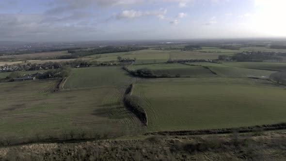 Idyllic British farming meadows countryside fields aerial view slow aerial shot.