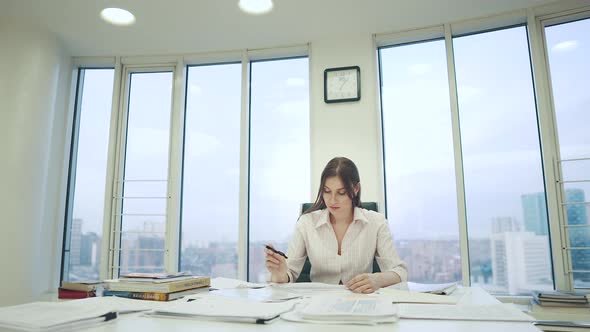 Girl in a Business Suit Working in the Office Sitting at the Table