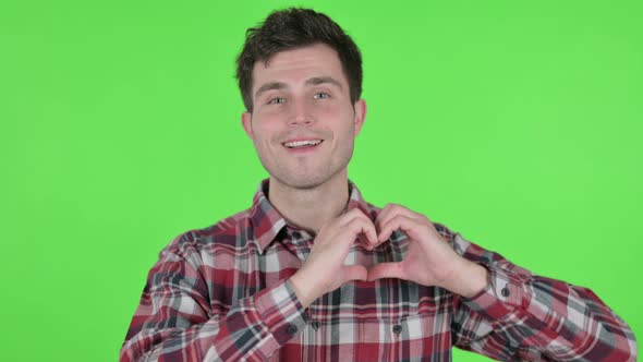 Portrait of Young Man Showing Heart Shape By Hands Green Chroma Screen