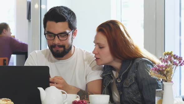 Lovely Couple Using Gadgets Together While Having Breakfast at the Coffee Shop