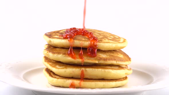 Pancakes with strawberry topping on a white background.