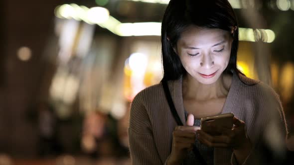 Woman using cellphone at night 