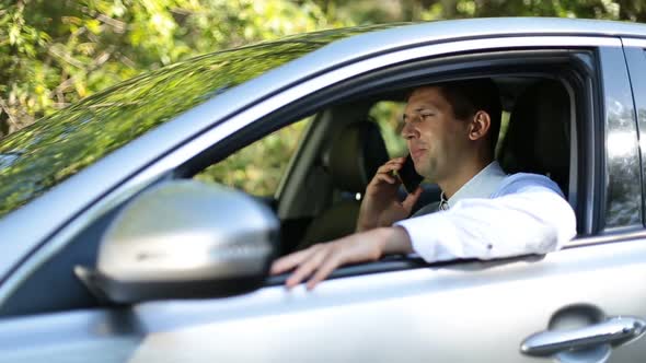 Handsome Businessman Talking on Phone in Car