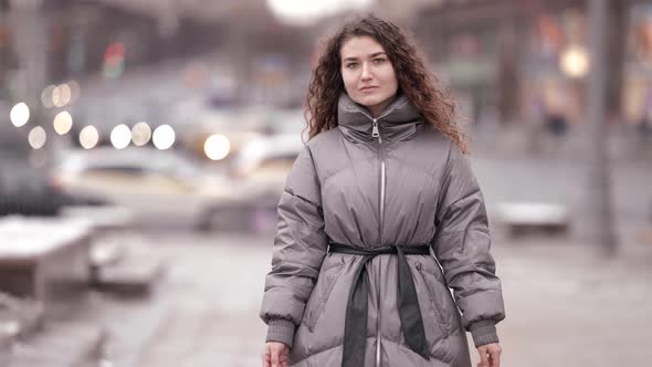 Young Female Passerby is Walking Alone on City Street at Winter Season