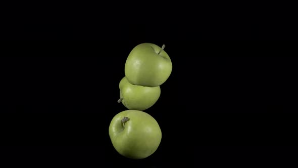 Flying Green Apples on a Black Background