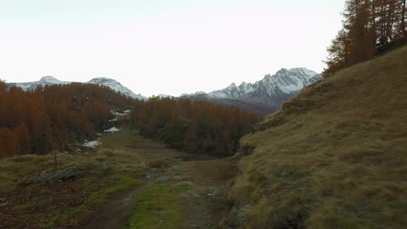 POV Walking on Fall Field Path Near Lake with Snowy Mounts