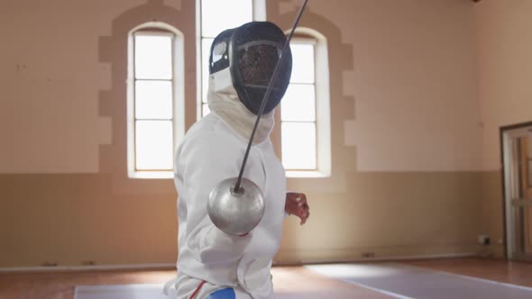 Female fencer athlete during a fencing training in a gym