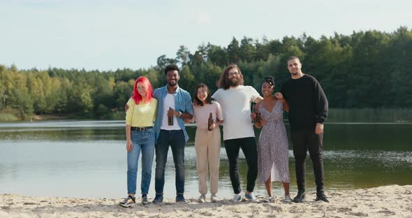 Portrait of Six Friends Having Fun Together By the Lake on the Beach Loosely Dressed Spending the