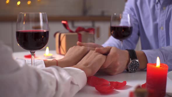 Candlelight Date For Valentine's Day. A Couple In Love Holds Hands On A Table. Two Glasses Of Wine