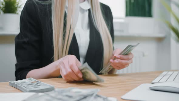 Business Woman Counting Cash in Hands. Crop View of Female in Elegant Suit Sitting at Wooden Desk