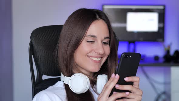 Happy Smilling Woman in Headphones with Smartphone at Home