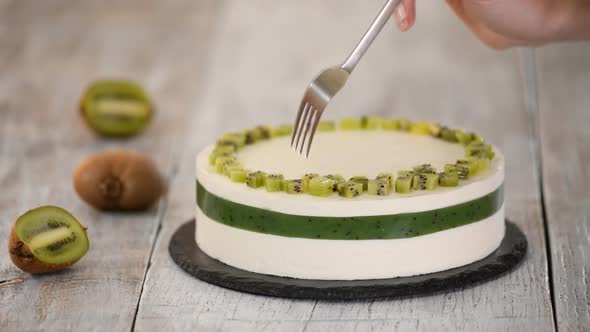 Chef decorate the cake with fresh kiwi, Homemade mousse cake with kiwi