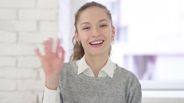 Portrait of Attractive Young Latin Woman Waving at the Camera