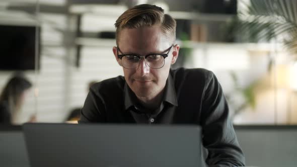 Young Man Freelancer Using Laptop Online Working From Office In Internet, Smiling Focused Millennial