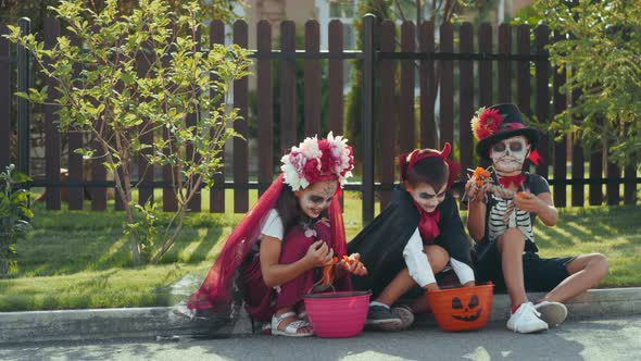 Excited Kids in Halloween Costumes Looking at Candy