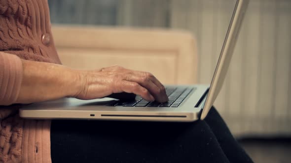 Senior Woman Hands Typing On Laptop Keyboard. Mature Woman Using Computer Browsing Social Networks.