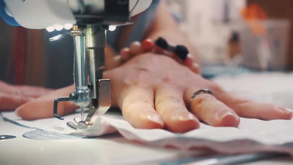 Hands of seamstress using sewing machine