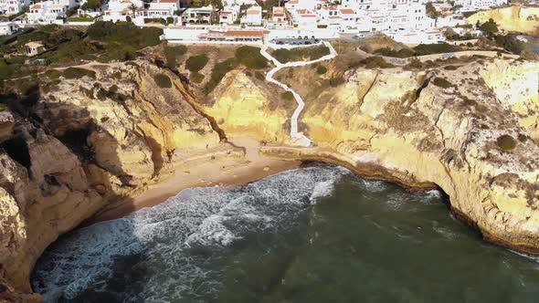 Waves crashing into sandstone cliffs in Carvoeiro, Algarve, Portugal