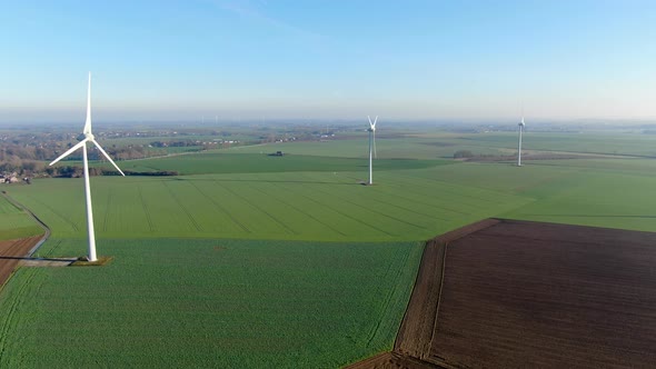 Aerial View of Wind Turbines on Agricultural Fields During Blue Winter Day