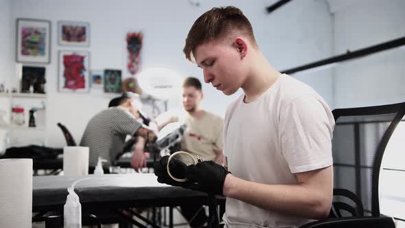 Tattoo Salon  Young Man Master Taping the Tattoo Machine with Duct Tape