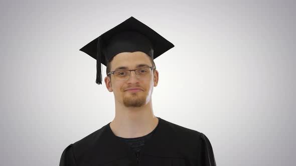 Happy Man in Graduation Gown Taking Off Medical Mask Virus in Over on Gradient Background