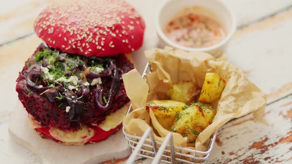 Homemade Vegetable Beetroot Burgers. Red Colored Sesame Bun. Served with Goat Cheese, Feta