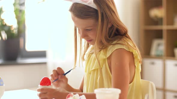 Happy Girl Coloring Easter Eggs at Home 4