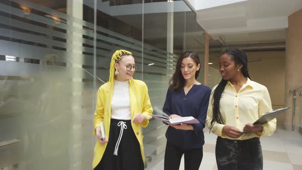Three Beautiful Business Women Walking in the Office and Discussing Project