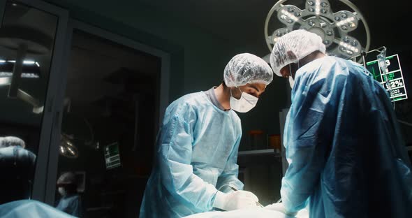 A Team of Surgeons Perform an Operation in a Bright Operating Room