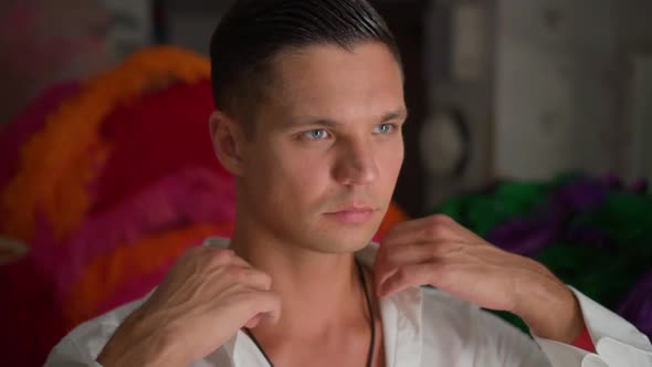 Dance Performer Adjusts White Shirt Collar in Front of Mirror in Dressing Room