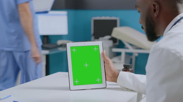 African American Specialist Doctor Looking at Mock Up Green Screen Chroma Key Tablet