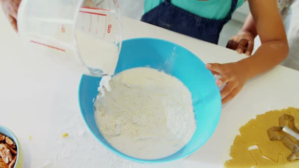 Multi-generation family preparing cookies in kitchen