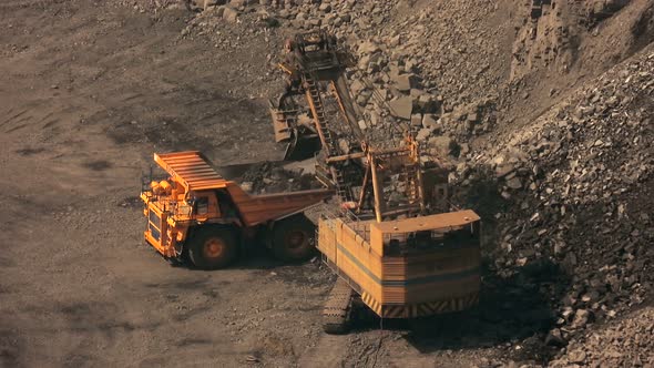 Big backhoe loader is loading ore on a mining dump truck time lapse.