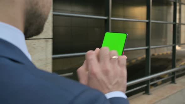 Businessman Looking at Smartphone with Green Chroma Screen