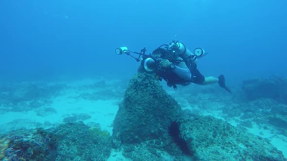 A video of an underwater cameraman taking photos in the ocean of marine life with underwater equipme