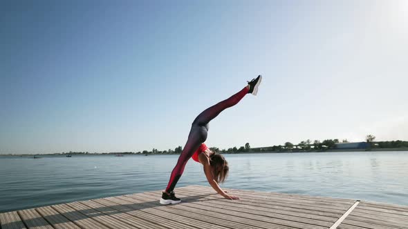 Young athletic Caucasian girl raises her leg in split. Stretching Flexibility.