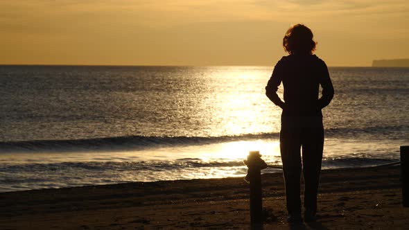 Woman Walking on Beach at Morning.