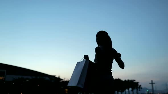 Slow Motion of Woman Holding Shopping Bags at Sunset Time