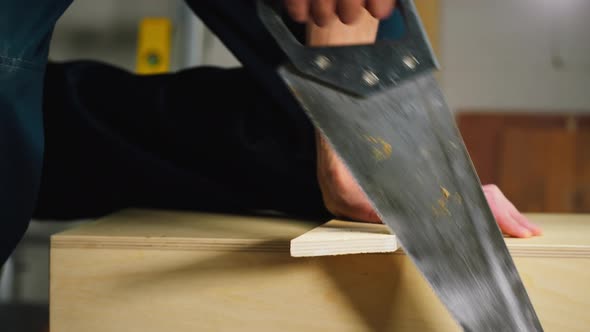 Man Builder Using Hand Saw Closeup