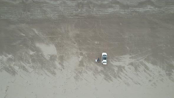 Rising drone car parked on  Inch beach Dingle peninsula Ireland overhead drone aerial view